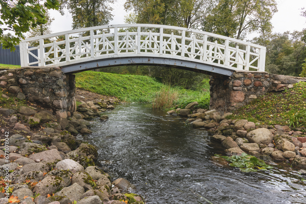 A wooden pedestrian bridge with a metal frame over the stream