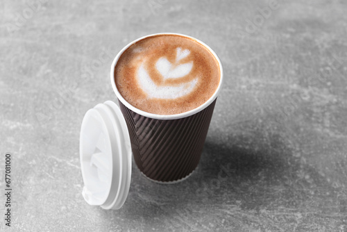 Coffee to go. Paper cup with tasty drink on grey table photo