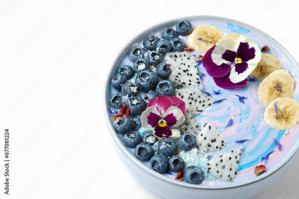 Delicious smoothie bowl with fresh fruits, blueberries and flowers on white background, closeup. Space for text Delicious smoothie bowl with fresh fruits, blueberries and flowers on white background, closeup. Space for text