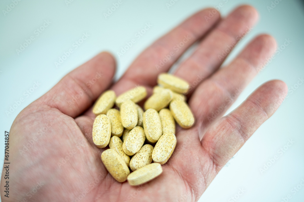 A hand shows various vitamin and supplement pills A hand shows various vitamin and supplement pills