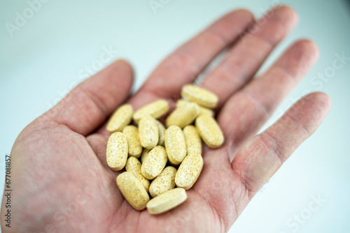 Wallpaper Mural A hand shows various vitamin and supplement pills Torontodigital.ca