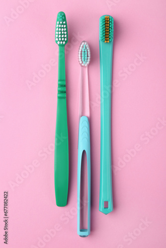 Many different toothbrushes on pink background  flat lay