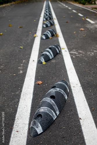 detail of line of speed bumps that separates a road from a bike lane © oscar