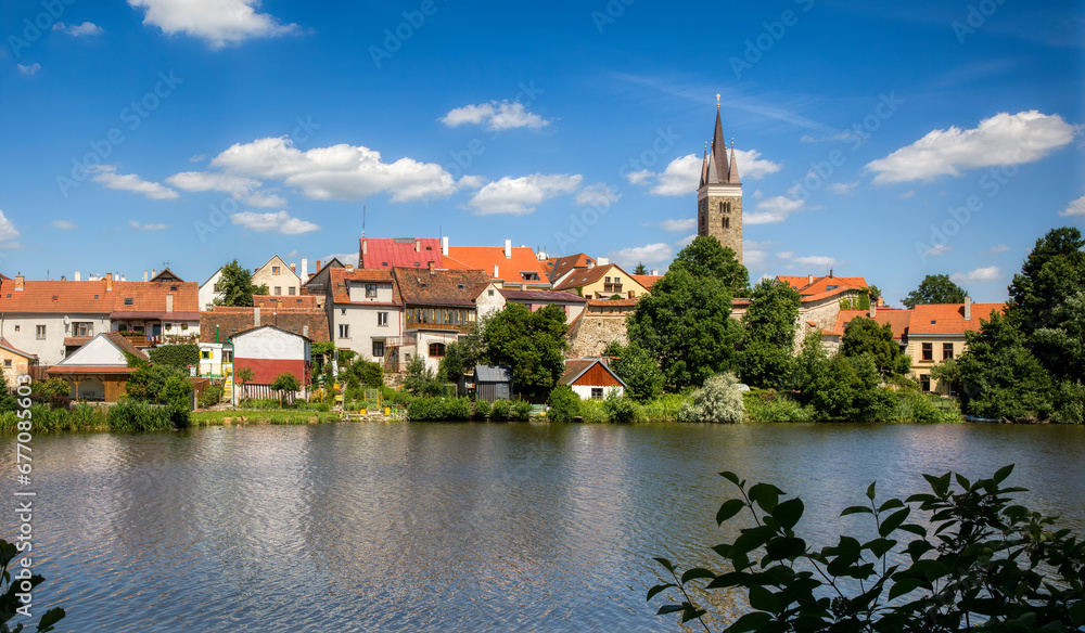 Houses in Beautiful Telc by the Lake Ulicky Rybnik in the Czech Republic, with the Tower of the Church of the Holy Spirit