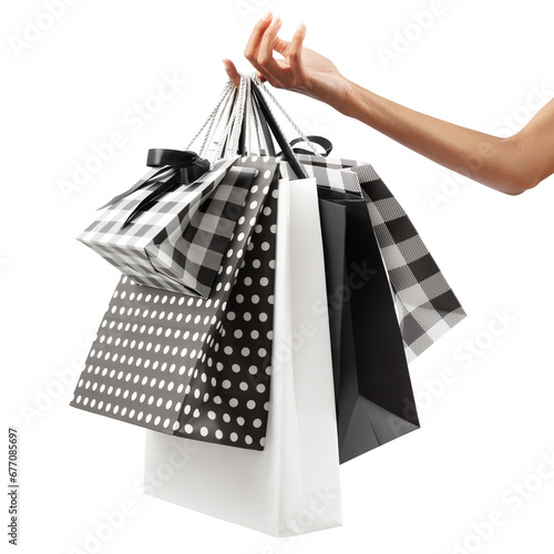 Female hand holding many shopping bag black and white color, isolated on white background. Concept of black friday week sale