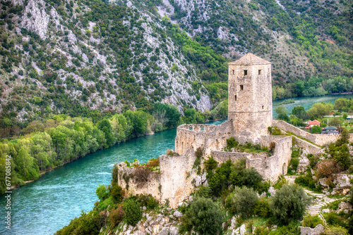 The Tower of the Kula Fort in the Historic Village of Pocitelj in Bosnia and Herzegovina, with the River Neretva photo