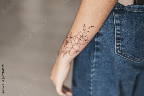 a close up view of woman showing her finished flowers tattoo on her hand