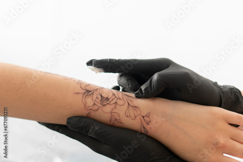 tattoo artist in black gloves applying cream on woman s arm