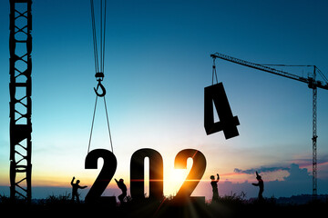 Silhouette of construction worker with crane and cloudy blue sky for preparation of welcome 2024 new year party and change new business.
