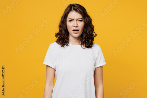 Wallpaper Mural Young sad displeased dissatisfied indignant Caucasian woman she wearing white blank t-shirt casual clothes looking camera isolated on plain yellow orange background studio portrait