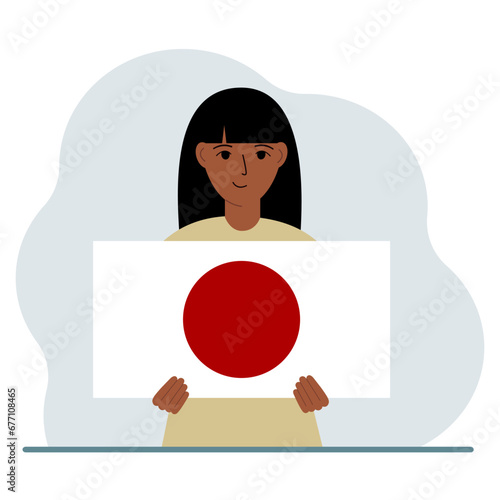 A woman holds the flag of Japan in his hands. The concept of demonstration, national holiday or patriotism. Nationality.