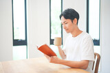 自宅のリビングで読書をする若い男性