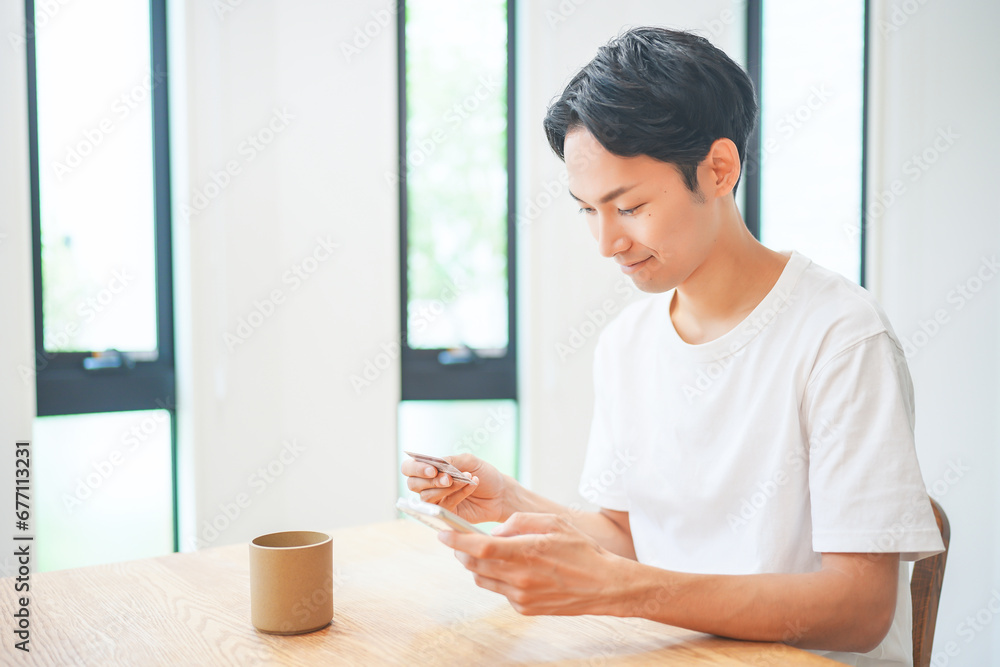 スマートフォンでクレジットカード決済をする若い男性