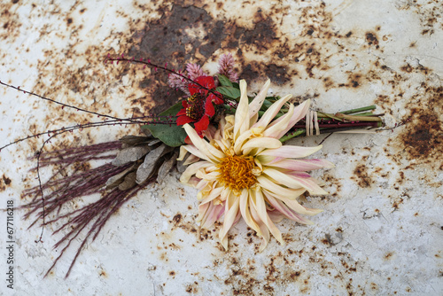 Garden flowers on vintage white and rust-coloured table. Top View. Garden style with grasses and flowers

