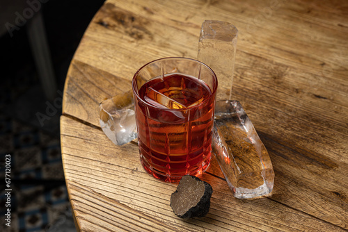 The Negroni alcoholic cocktail with truffle on a wooden table