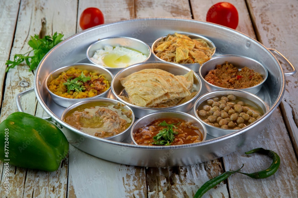 a tray filled with various food in bowls on a wooden table