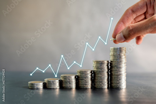 Hand stacking coins on black wooden table with profit line chart growth up. Business, finance, marketing, e-commerce concept and design photo