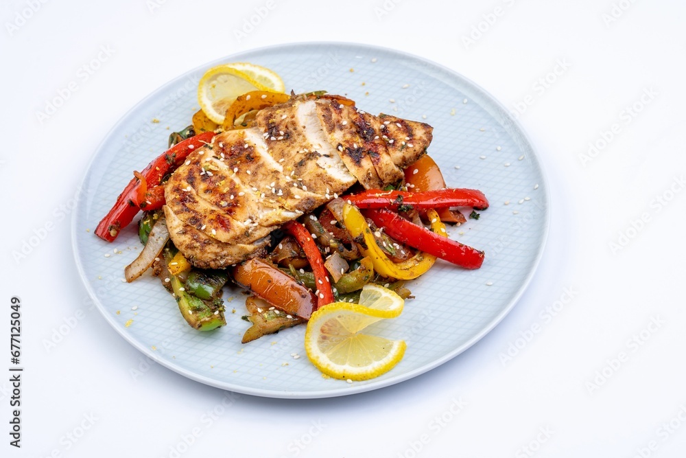 a plate with chicken, peppers and lemons on it a plate with chicken, peppers and lemons on it