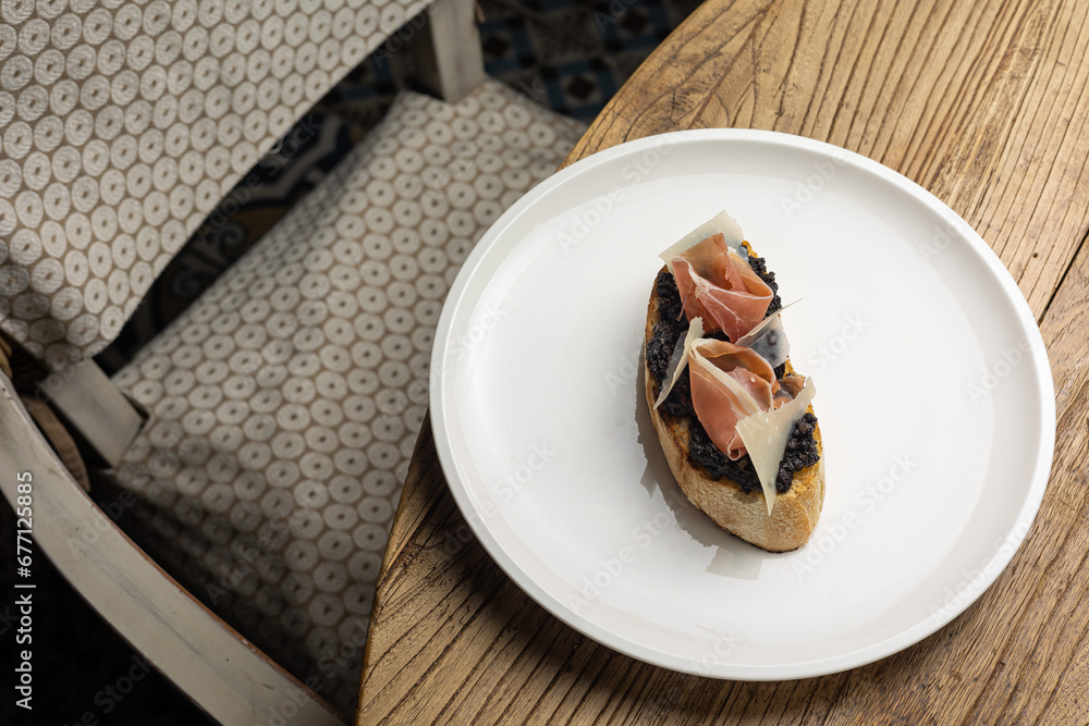 Tasty bruschetta with jamon and cheese on a wooden table Tasty bruschetta with jamon and cheese on a wooden table