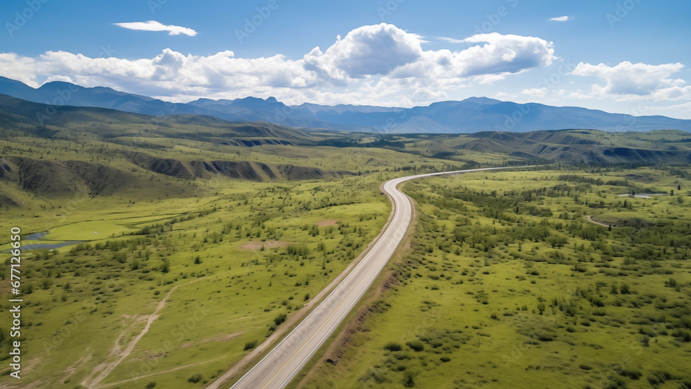 An empty road in an endless grassland seen from a drone