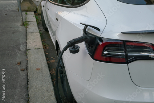 electric car charging, plug in to draw energy in the dedicated car park. Zero emissions in cities with green ecological policies. bonuses © rikstock