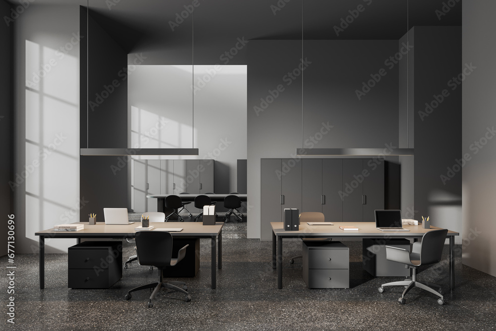 Grey coworking interior with desk and chairs in row, meeting space on background Grey coworking interior with desk and chairs in row, meeting space on background