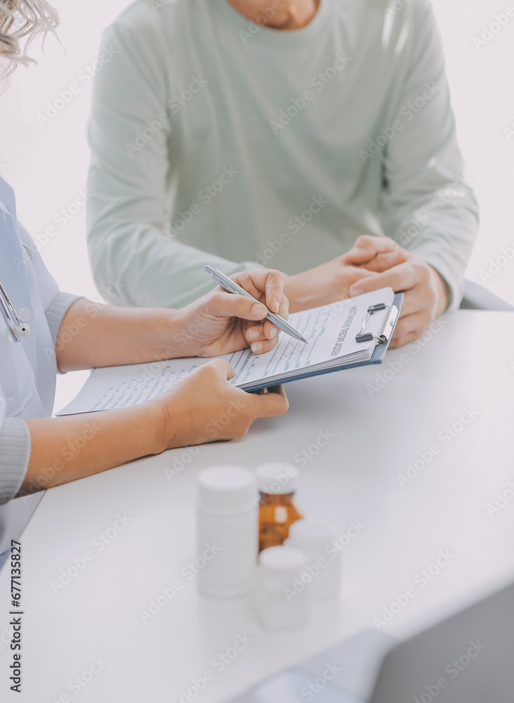 Mature Asian male doctor talking with his patient, explaining the procedure to old lady. Mature Asian male doctor talking with his patient, explaining the procedure to old lady.