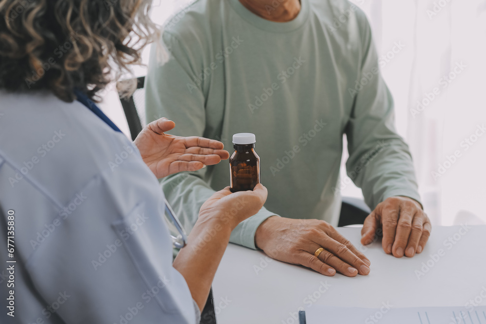 Mature Asian male doctor talking with his patient, explaining the procedure to old lady. Mature Asian male doctor talking with his patient, explaining the procedure to old lady.