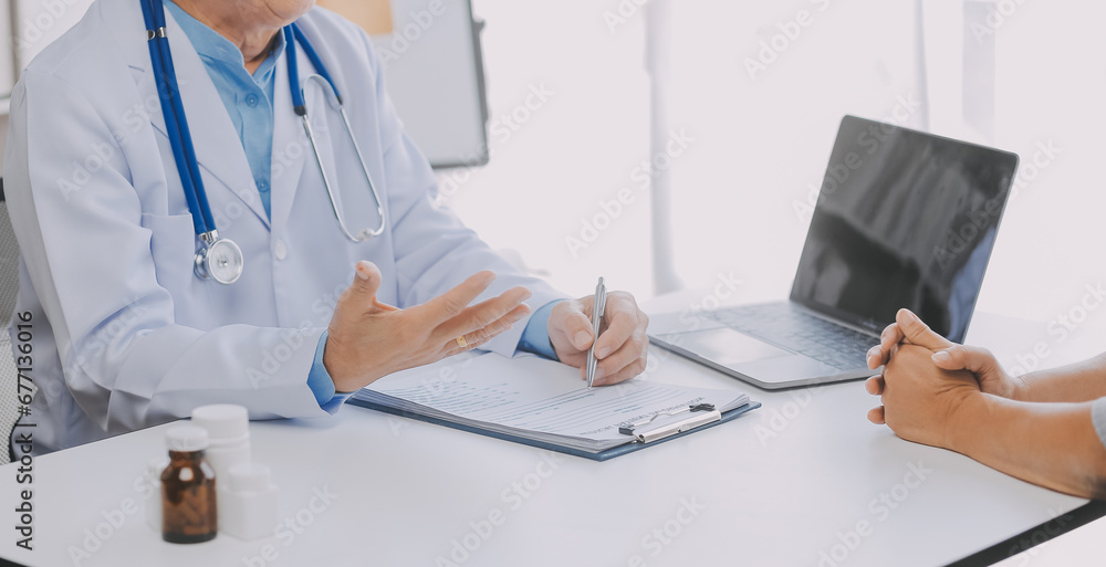 Mature Asian male doctor talking with his patient, explaining the procedure to old lady. Mature Asian male doctor talking with his patient, explaining the procedure to old lady.