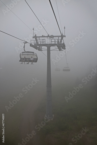 Cabins of cable car funicular in thick white fog.