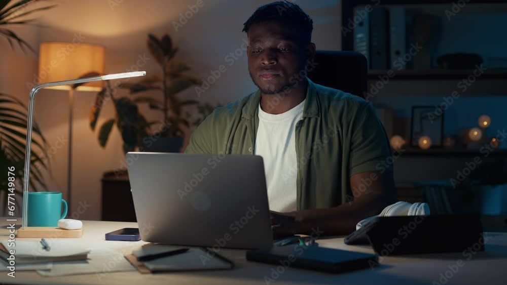 Pensive freelancer using laptop for evening work at home Pensive freelancer using laptop for evening work at home