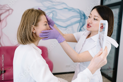 Professional cosmetologist examining face of client