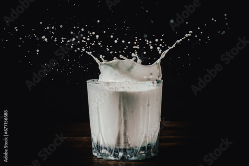 Splashing milk in glass On black background