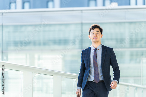 オフィス街を颯爽と歩く男性ビジネスマン photo