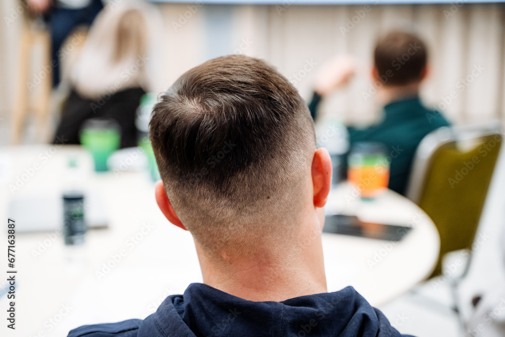 A shaved head, the back of a person's head, a neat haircut. Back view of a person on the background of a business lounge. A shaved head, the back of a person's head, a neat haircut. Back view of a person on the background of a business lounge.