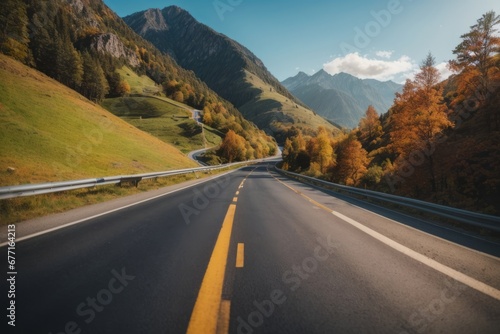 Beautiful asphalt road with a yellow stripe in the middle of high mountains. A clear sunny day, blue sky with white clouds, yellow and green fields. Nature, travel concepts