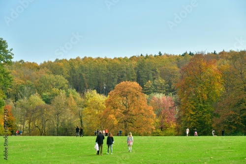 Détente sur la grande pelouse en face d'une forêt aux couleurs d'automne au domaine du château de la Hulpe 
