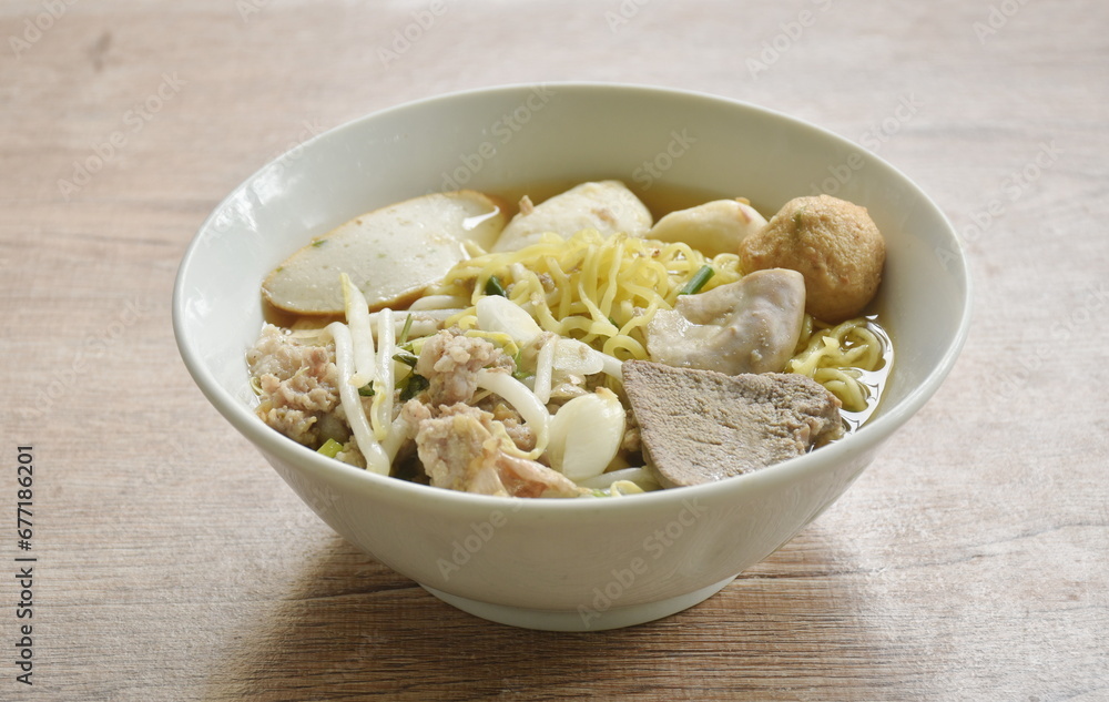 boiled Chinese yellow egg noodles with entrails and fish ball in soup on bowl