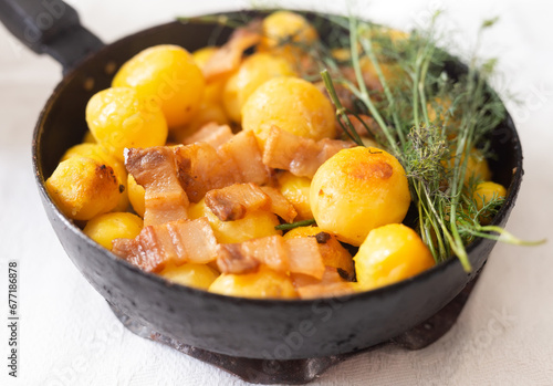Young potatoes with pork belly fried in frying pan