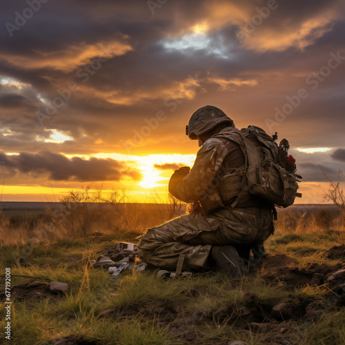 Photograph of a soldier kneeling after praying at sunrise.