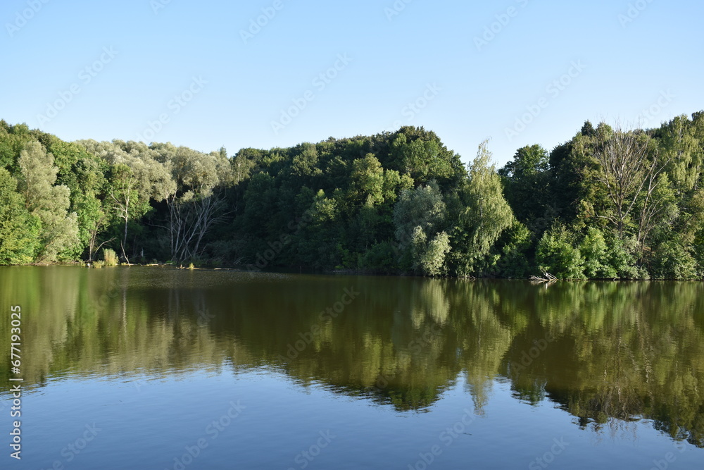 Natural reflections, mirror effect on water, lake in Poltava region, Ukraine Natural reflections, mirror effect on water, lake in Poltava region, Ukraine