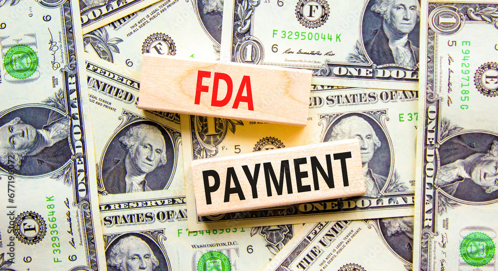 FDA Food and Drug Administration payment symbol. Concept words FDA payment on beautiful wooden blocks. Dollar bills. Beautiful background from dollar bills. Business FDA payment concept. Copy space.