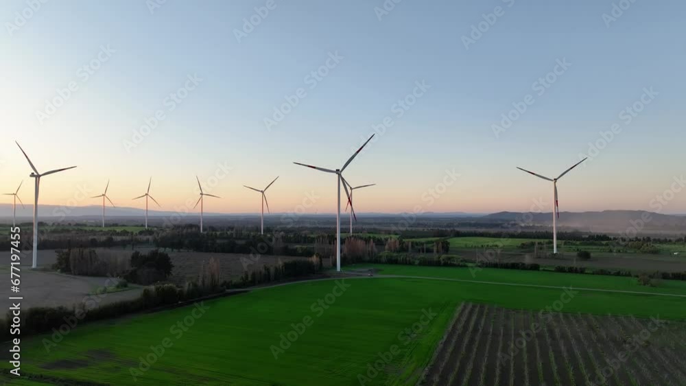 Wind turbine eco farm on beautiful purple evening mountain landscape. Renewable energy production for green ecological world. Aerial view of wind mills farm park Wind turbine eco farm on beautiful purple evening mountain landscape. Renewable energy production for green ecological world. Aerial view of wind mills farm park