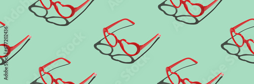 Pattern made with red heart shaped sunglasses on pastel color background