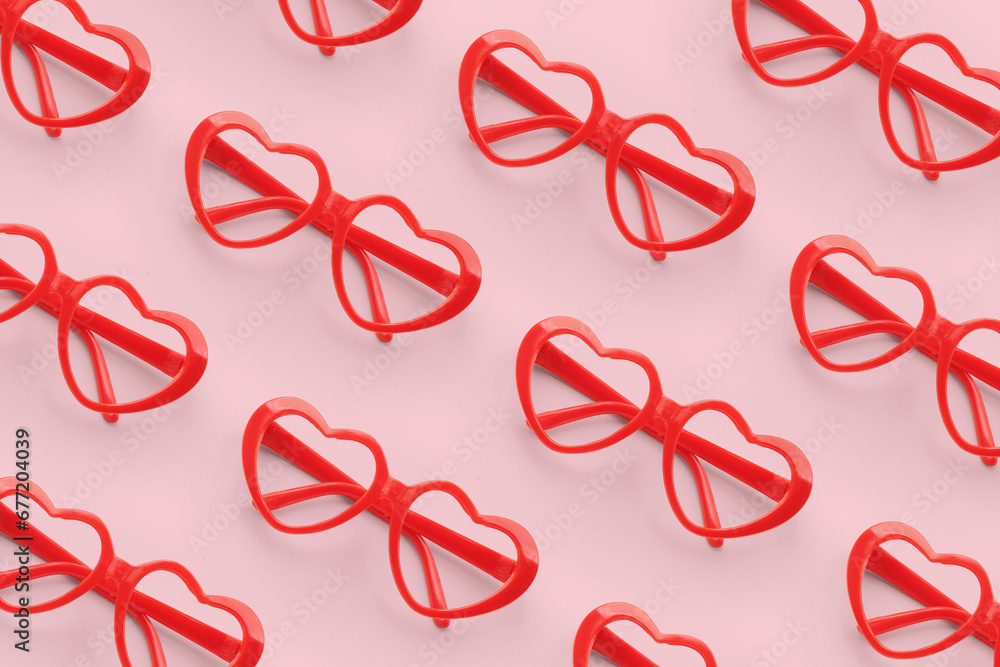 Pattern made with red heart shaped sunglasses on pastel color background Pattern made with red heart shaped sunglasses on pastel color background