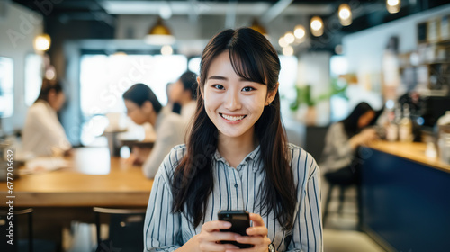  smile asian woman in working space.hold phone woman using phone in cafe