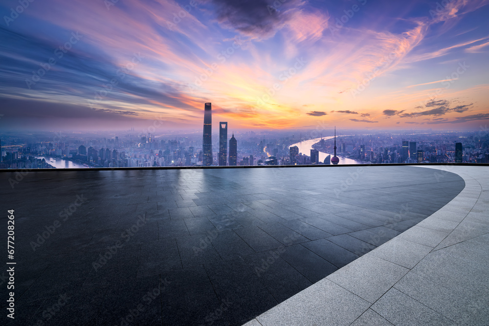 Square floor and city buildings skyline in Shanghai at sunset