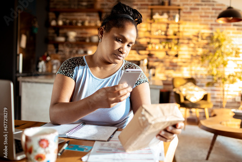 Woman taking picture of package at home photo