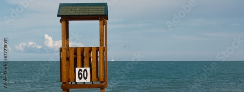 Particolare di una spiaggia con torretta per bagnino e sfondo del mare photo