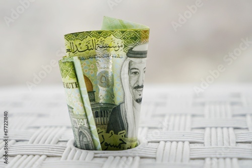 Closeup shot of green Saudi Arabia banknotes, wedged in a white surface, the concept of savings photo